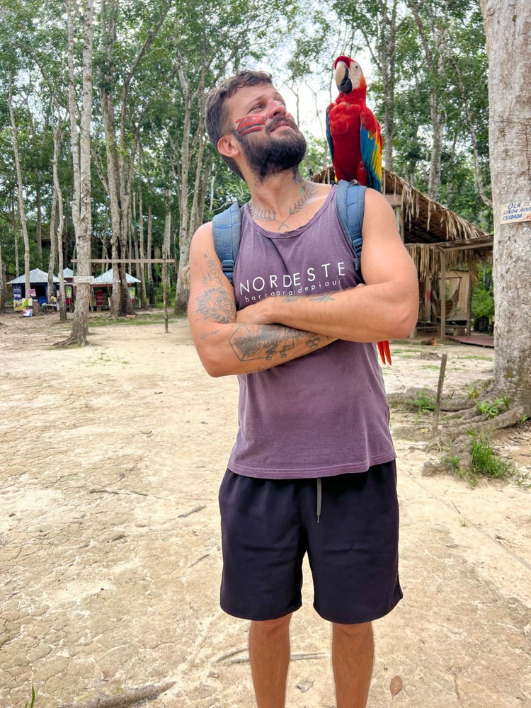 Alexander com uma arara no ombro, numa comunidade na floresta